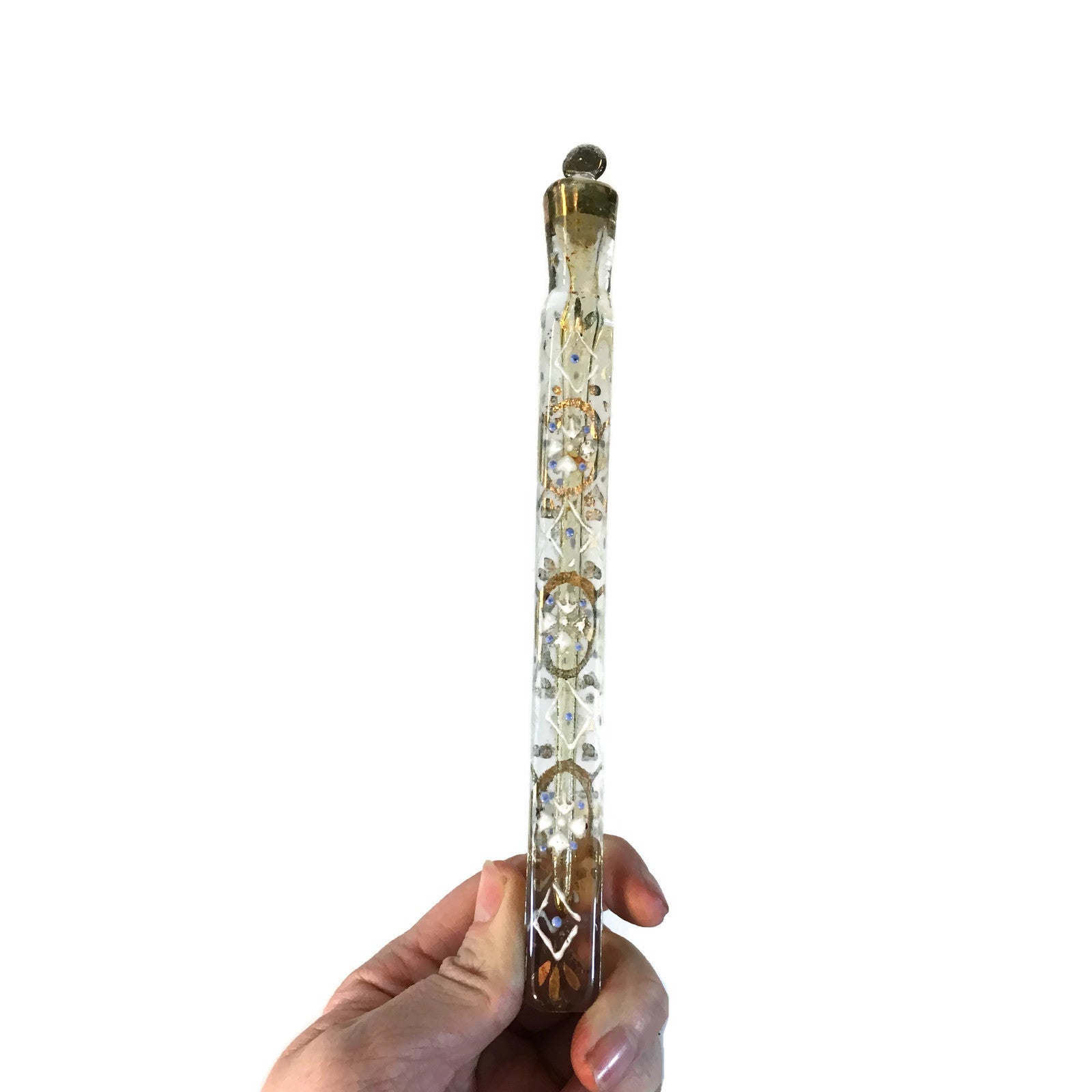 A Victorian glass lachrymatory bottle with a teardrop-shaped body and intricate patterns, featuring silver-colored accents.