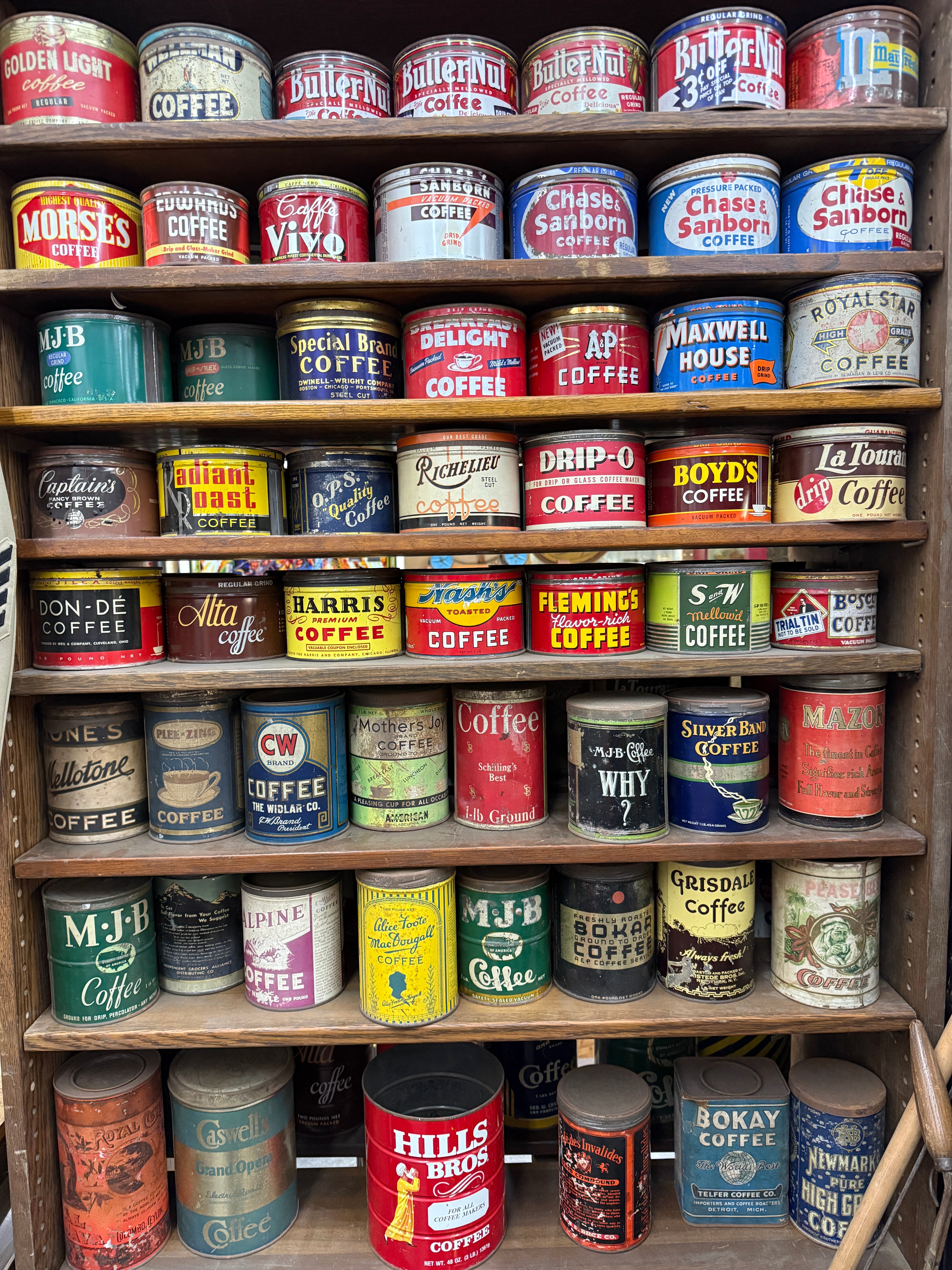 Collection of vintage coffee cans on a wooden shelf